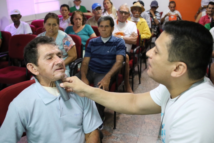 Raimundo Napoleão Abreu, 62, faz o teste da laringe eletrônica pela primeira vez com ajuda de fonoaudiólogo (Foto: Fábio Lima/O POVO)