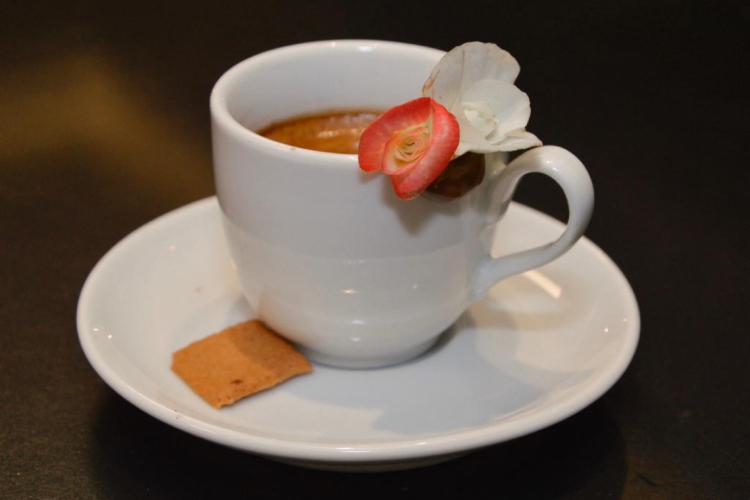 O café servido é acompanhado de uma flor comestível