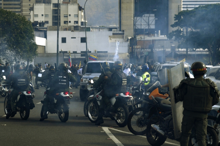 Membros da Guarda Bolivariana Nacional, leal ao presidente Nicolas Maduro, em confrontos nas ruas de Caracas
