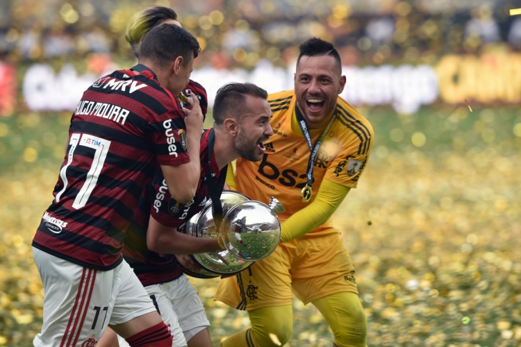 ￼ Capitão Everton Ribeiro com a taça de campeão da Libertadores; de amarelo, goleiro Diego Alves