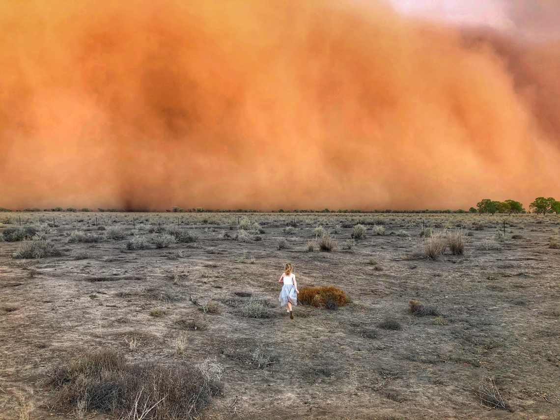 AUSTRALIA, 17 de Janeiro 17, 2020, Criança corre de uma tempestade de poeira em Mullengudgery, em New South Wales Australia. (Photo by Handout / Courtesy of Marcia Macmillan / AFP) / RESTRICTED TO EDITORIAL USE - MANDATORY CREDIT 