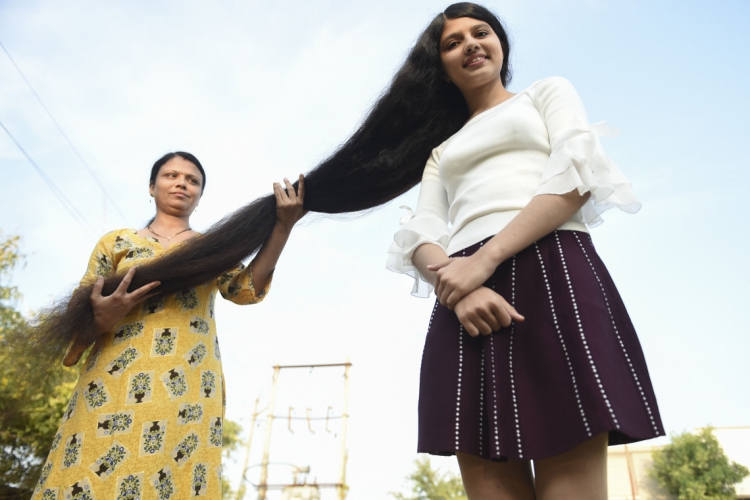 Nilanshi Patel, 17, que ganhou o Guinness World Record 2019 de cabelos mais compridos na categoria adolescente, 190 cm, posa para uma foto com sua mãe Kaminibenat na cidade de Modasa, a 110 km de Ahmedabad em 19 de janeiro de 2020      Caption