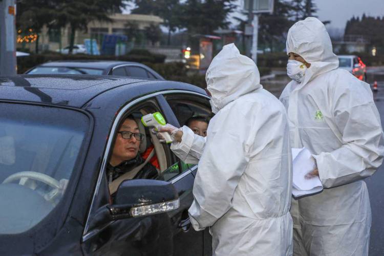 Membros da equipe médica vestindo roupas de proteção para ajudar a impedir a propagação do corona, na China  (Foto: STR / AFP )