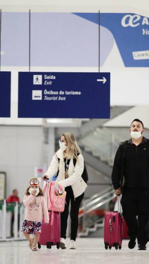 Pessoas com máscaras embarcando e desembarcando de vôos internacionais no Aeroporto Pinto Martins, em Fortaleza