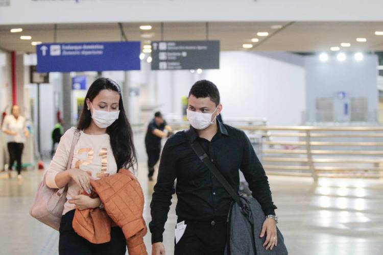 FORTALEZA, CE, Brasil. 12.03.2020: Movimentação de pessoas no Aeroporto Internacional Pinto Martins se prevvenindo do COVID-19 (Coronavírus). Pessoas com máscaras embarcando e desembarcando de vôos internacionais. (Foto: Júlio Caesar/  O POVO)