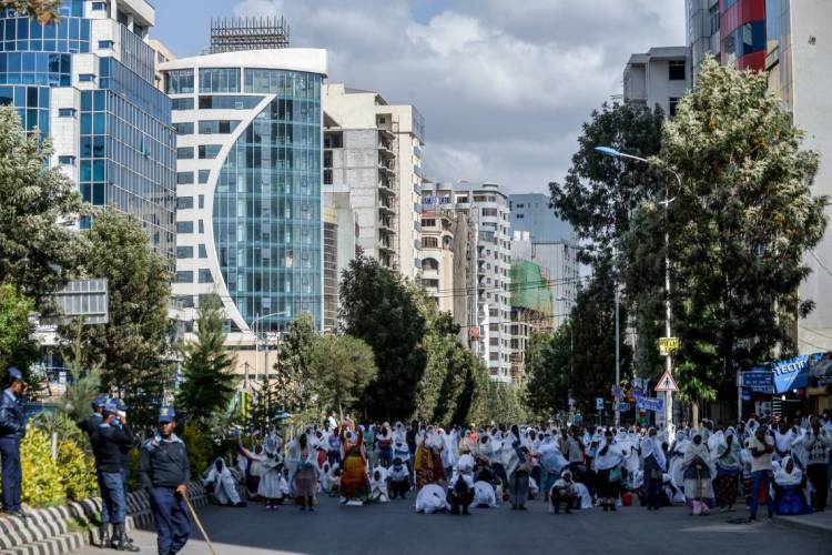 Etiópia é atingida pela epidemia de Covid-19 e também pelos gafanhotos. Na foto, cristãos ortodoxos oram na rua após terem acesso bloqueado á catedral devido à pandemia