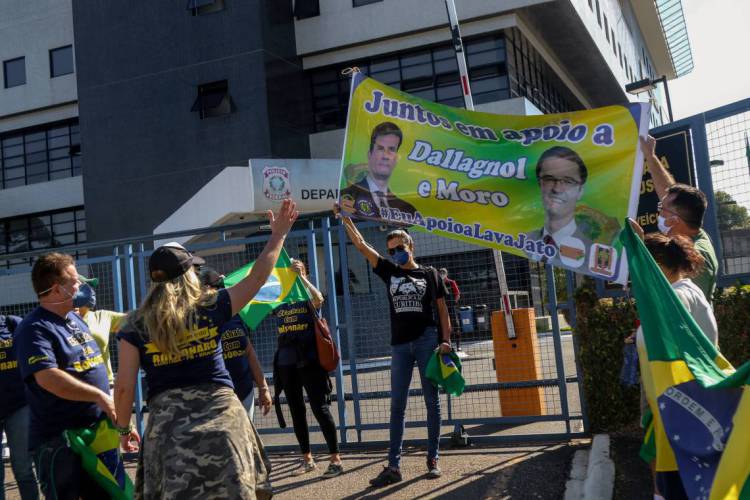 Supporters of the ex-Brazilian Minister of Justice and Public Security, Sergio Moro (R) and supporters of Brazil President Jair Bolsonaro (L) argue in front of the Federal Police headquarters where Moro is expected to testify about his accusation against Bolsonaro that he was trying to intervene investigations of the Brazil Federal Police, in Curitiba, Parana State, Brazil, on May 2, 2020. - Brazilian supreme court Celso de Mello gave the federal police on April 27, 2020 60 days to question Moro about his explosive allegations that Bolsonaro sought to 