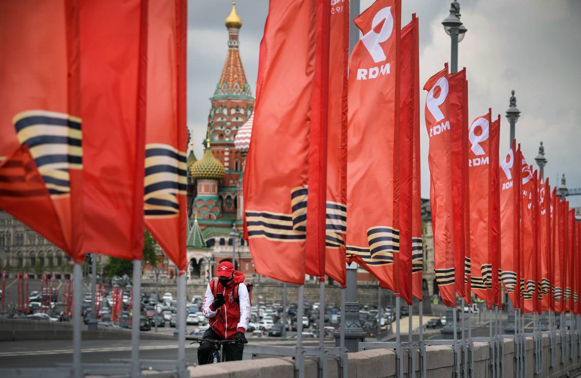 Moscou, em 6 de maio de 2020, Um ciclista passa pelas faixas vermelhas dedicadas ao Dia da Vitória(Foto: Alexander NEMENOV / AFP)