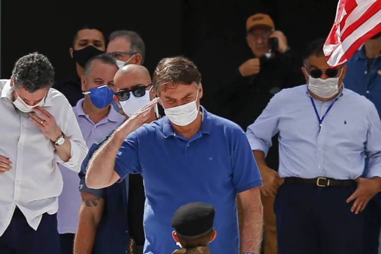 O presidente brasileiro Jair Bolsonaro (saúda uma criança em traje militar durante uma manifestação em Brasília, em 17 de maio de 2020, em meio à nova pandemia de coronavírus