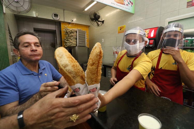 ￼Heitor Férrer prestes a saborear um pastel do Leão do Sul