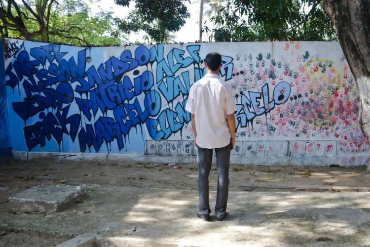 Homem observa nomes das vítimas da chacina grafitados em muro da Escola Professora Terezinha Ferreira no Curió. Dois meses após a chacina na Grande Messejana.