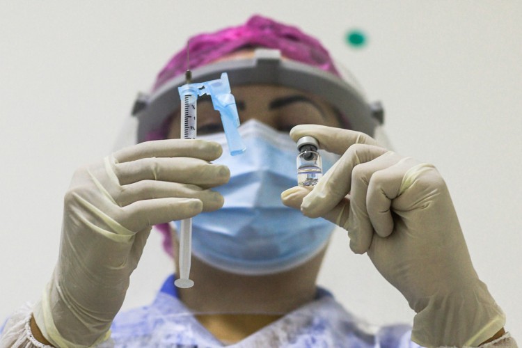 Clínicas particulares entram em negociação pela vacina indiana contra Covid-19. Empresas como Unimed e Emílio Ribas estão interessadas. As fotos destacam enfermeira com vacina na Previne Clinica, com fotos de seringa e ampola de vacina e o freezer de armazenamento. Sapiranga, Fortaleza