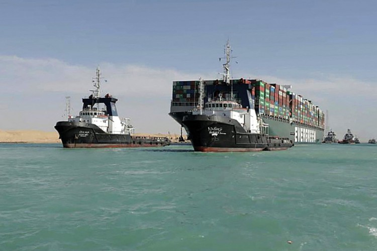 Rebocador puxando o navio porta-contêineres MV 'Ever Given' com bandeira do Panamá depois que ele foi totalmente desalojado das margens do Suez