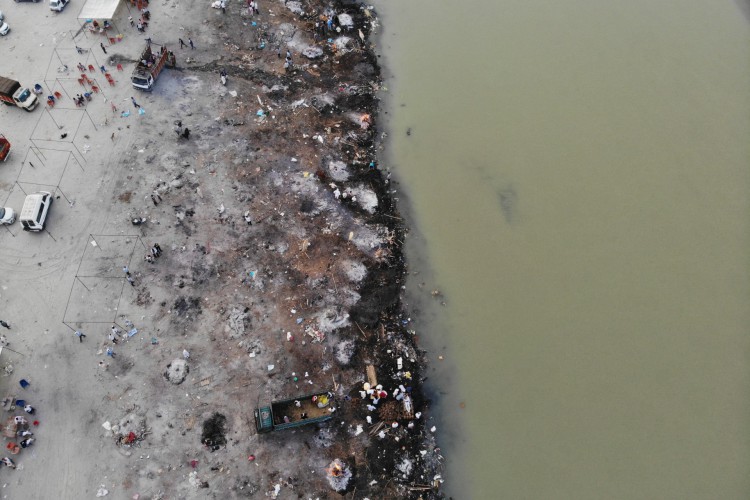 Nesta fotografia aérea tirada em 5 de maio de 2021 piras funerárias de vítimas do coronavírus Covid-19 são vistas em um campo de cremação ao longo das margens do rio Ganges, em Garhmukteshwar 