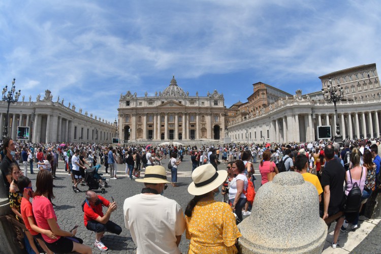 As pessoas ficam na praça de São Pedro enquanto o papa Francisco se dirige à multidão da janela do palácio apostólico durante sua oração do Angelus de domingo no Vaticano