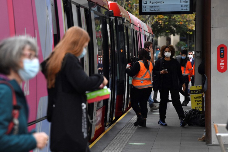 Passageiros usando máscaras desceram de um metrô em Sydney em 23 de junho de 2021, quando os residentes foram proibidos de deixar a cidade para impedir um surto crescente da variante Delta Covid-19