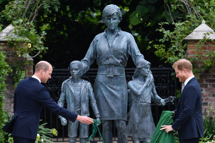 O príncipe William da Grã-Bretanha (esquerda) e o príncipe Harry com uma estátua da mãe, a princesa Diana no The Sunken Garden no Palácio de Kensington, Londres em 1º de julho de 2021