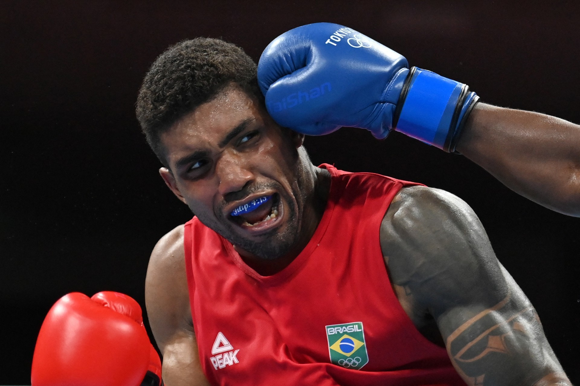 Abner Teixeira do Brasil (vermelho) e Julio La Cruz de Cuba lutam durante sua luta de boxe pesado masculino (81-91kg) durante os Jogos Olímpicos de Tóquio 2020 na Arena Kokugikan em Tóquio em 3 de agosto de 2021. (Foto de Luis ROBAYO / POOL / AFP) (Foto: LUIS ROBAYO / AFP)