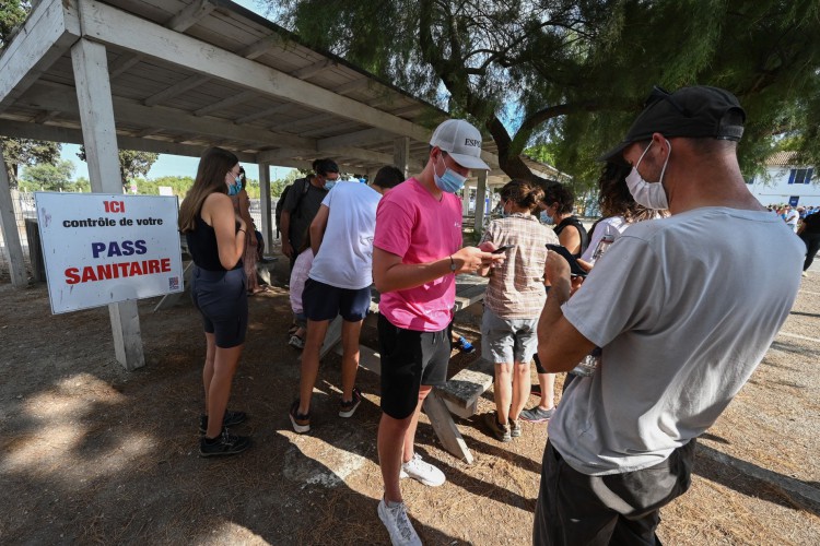 Turistas mostram seu passe de saúde na entrada das salinas em Aigues Mortes, no sul da França, em 3 de agosto de 2021