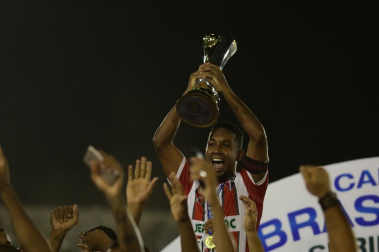 Leanderson erguendo a taça de campeão da Série D do Campeonato Brasileiro 2018