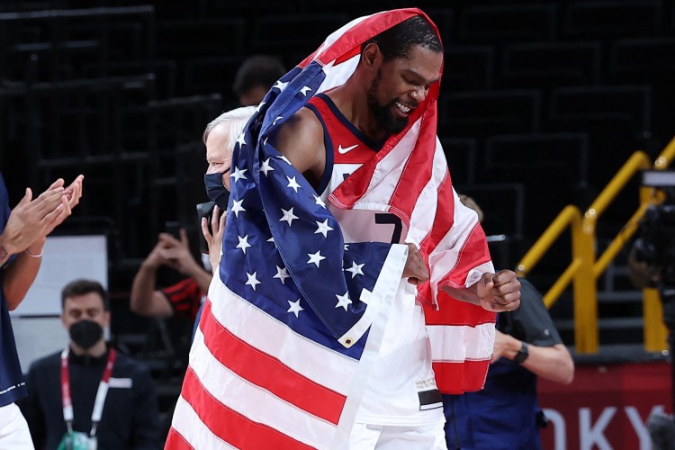 Kevin Durant comemora título da seleção de basquete nas Olimpíadas enrolado na bandeira dos Estados Unidos