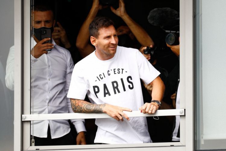 Messi acena para fãs de uma janela no aeroporto Le Bourget, em Paris