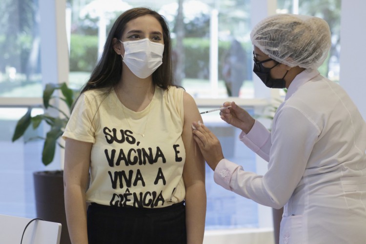 Garota veste blusa com apoio a ciência durante vacinação no Iguatemi