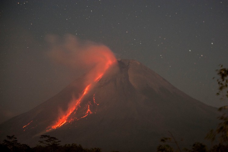 Esta foto tirada em 16 de agosto de 2021 mostra o Monte Merapi, o vulcão mais ativo da Indonésia, expelindo cinzas e lava de seu pico visto de Sleman em Yogyakarta