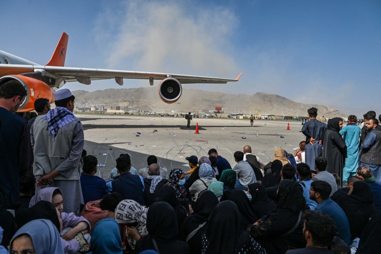 Povo afegão espera para deixar o aeroporto de Cabul em Cabul em 16 de agosto de 2021, após um fim incrivelmente rápido para a guerra de 20 anos do Afeganistão, enquanto milhares de pessoas se aglomeravam no aeroporto da cidade tentando fugir do temido tipo linha-dura de governo islâmico do grupo . (Foto de Wakil Kohsar / AFP)