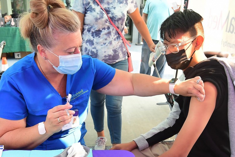 Roberto Ortega, 16, aguarda a vacina Pfizer Covid-19 administrada pela enfermeira registrada Amy Berecz-Ortega da AltaMed Health Services em Los Angeles, Califórnia em 17 de agosto de 2021