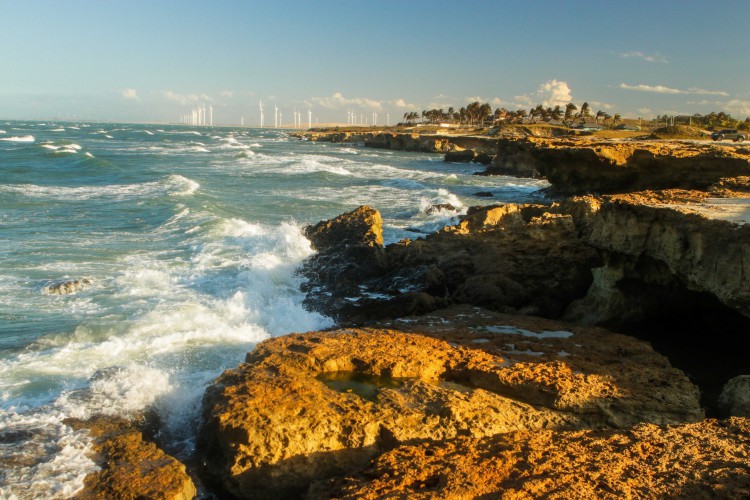 Praia de Pontal de Maceió, em Fortim. Ao fundo, fileira de eólicas onshore.