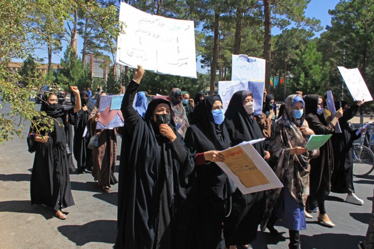 Mulheres afegãs seguram cartazes enquanto participam de um protesto em Herat em 2 de setembro de 2021