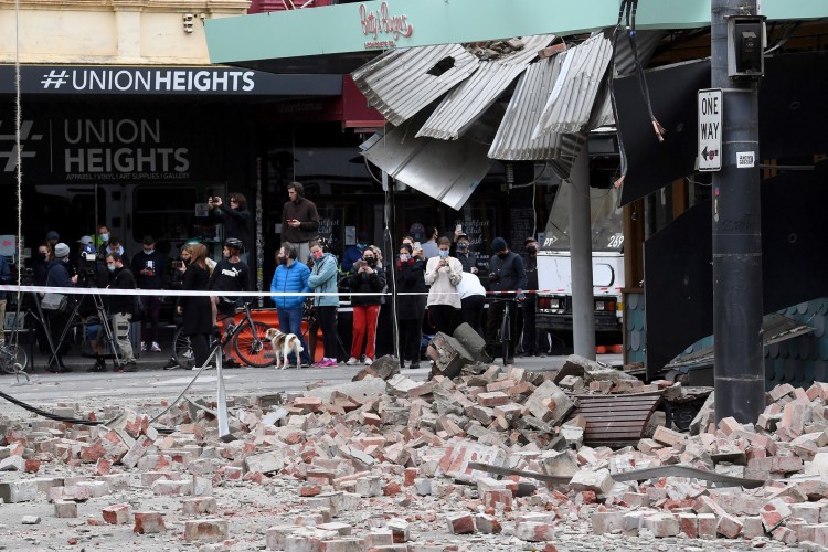 Moradores se reúnem perto de um prédio danificado na popular rua comercial Chappel Street, em Melbourne, em 22 de setembro de 2021, após um terremoto de magnitude 5,9