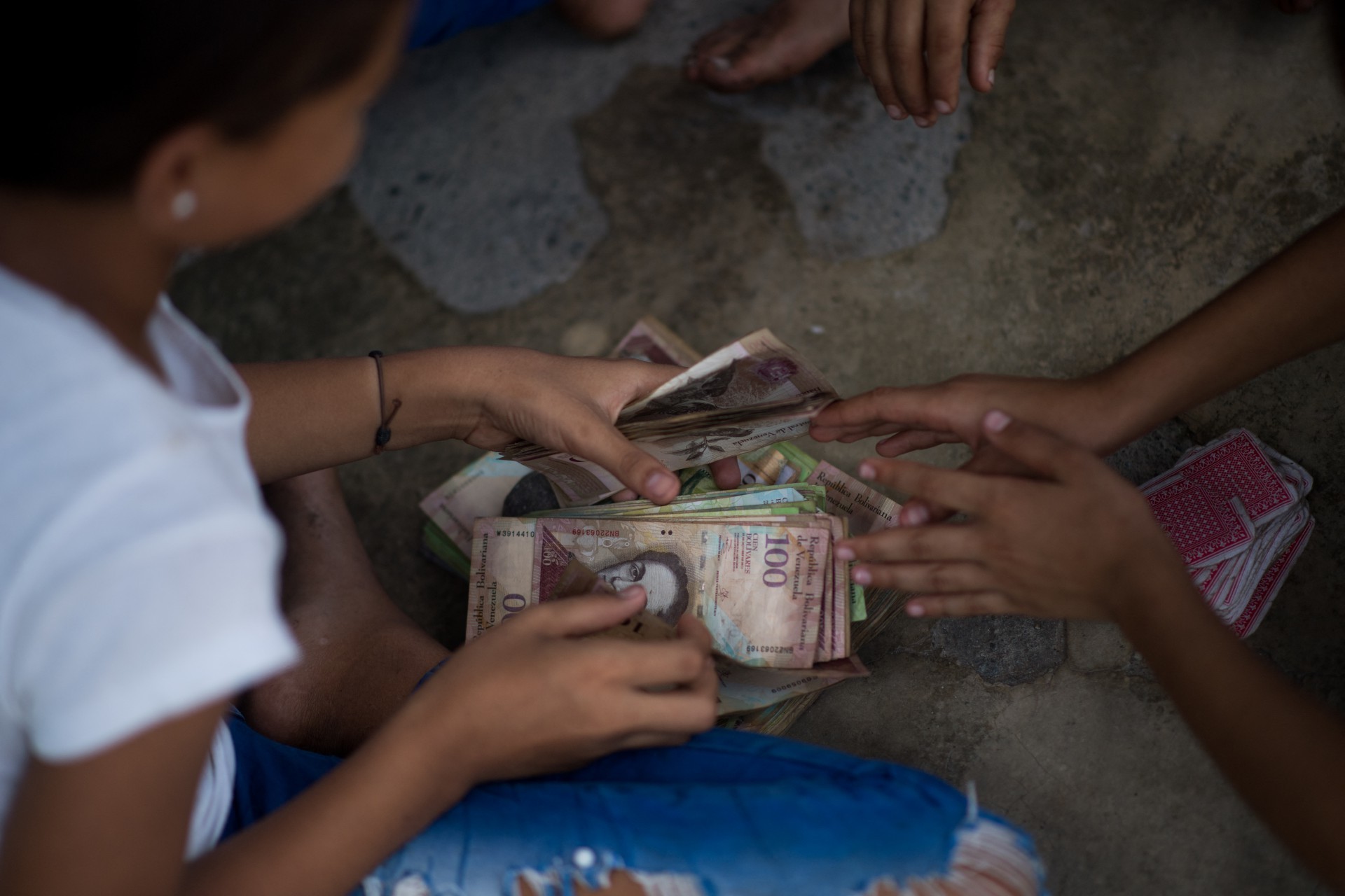 Crianças de povoado venezuelano brincam com cédulas em desuso 