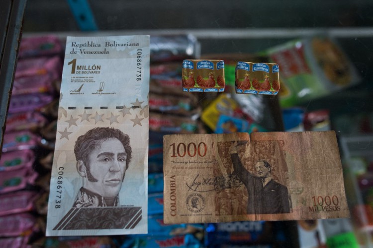 Nota de 1 milhão de bolívar venezuelano (e), que equivale a 1.000 pesos colombianos (d), que por sua vez vale o equivalente a dois temperos em uma loja de Puerto Concha, Venezuela