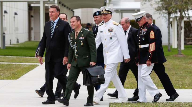 ￼MAURO Cid (de verde) caminha ao 
lado de Bolsonaro, em imagem de arquivo