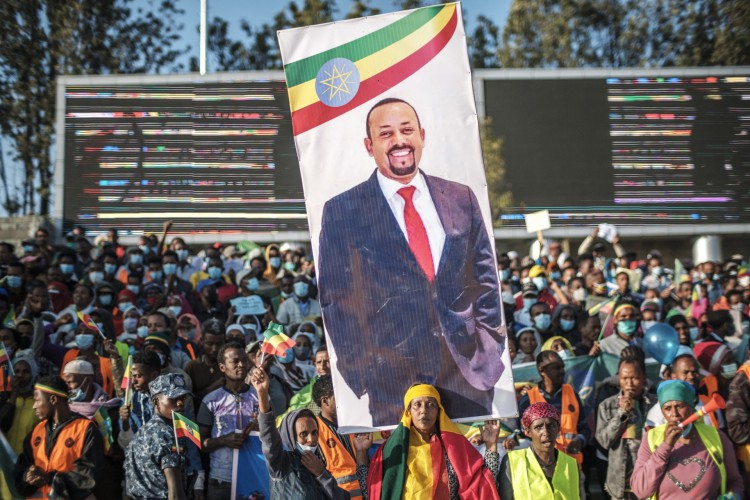 Mulher segura uma faixa com o retrato do Primeiro Ministro Abiy Ahmed durante um comício em Addis Abeba, Etiópia, em 7 de novembro de 2021