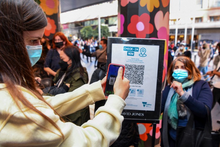 Cliente digitalizando um código QR para entrar em uma loja de departamentos em Melbourne