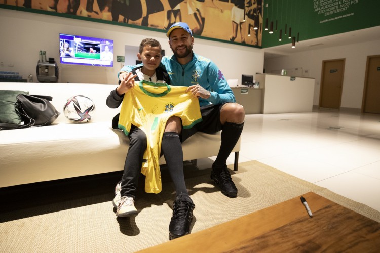 Bruninho, torcedor do Santos, recebe camisa de Neymar em visita ao treino da seleção brasileira, no CT do Palmeiras