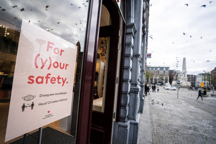 Esta foto, tirada em 24 de novembro de 2021, mostra uma placa indicando o respeito às regras de distanciamento social no centro de Amsterdã