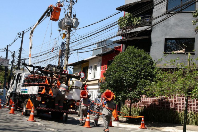 Funcionários da Enel fazem manutenção em poste de energia elétrica