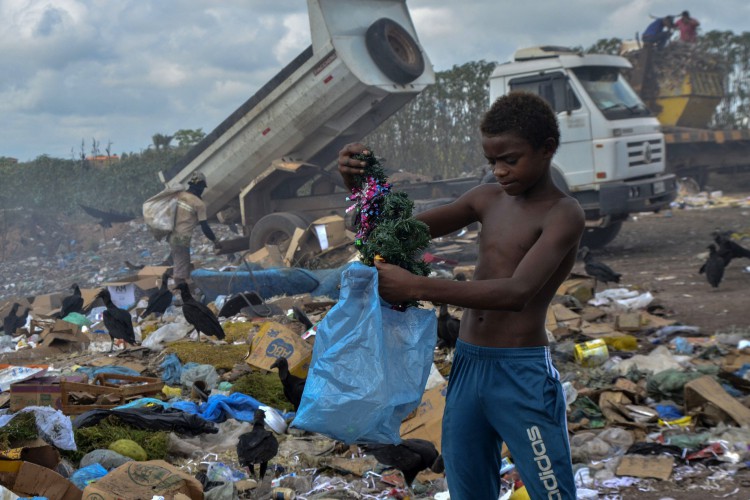 Menino encontra uma árvore de Natal enquanto vasculha o lixo no aterro da Picarreira, bairro Cidade das Águas, em Pinheiro, Maranhão, Brasil, em 08 de novembro de 2021.
