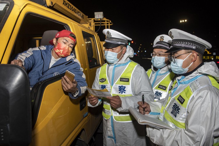 Policiais checam info0rmações de motorista na província de Zhejiang após surto de Covid-19