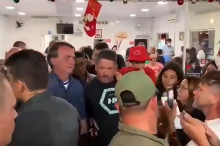 Registro de tela de vídeo do presidente Jair Bolsonaro em pizzaria lotada, nesta terça-feira, 29, em SC.