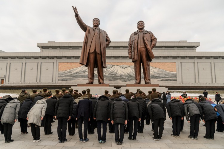 As pessoas se curvam para homenagear as estátuas do presidente Kim Il Sung e do presidente Kim Jong Il em Mansu Hill, em Pyongyang, por ocasião do dia de Ano Novo em 1º de janeiro de 2022