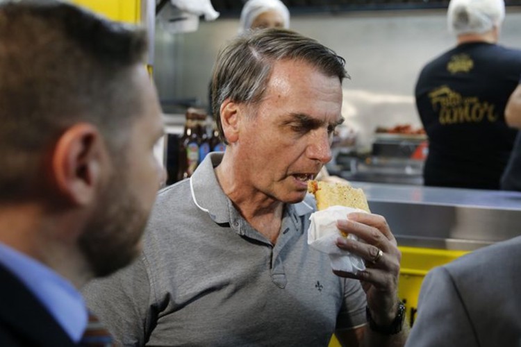 ￼ Jair Bolsonaro ao comer cachorro-quente no Hot Dog do Senhor,
 em Resende (RJ)