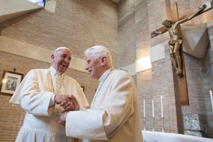 Foto divulgada pela assessoria de imprensa do Vaticano em novembro de 2016 mostra o papa Francisco (esquerda) apertando a mão do papa emérito Bento XVI