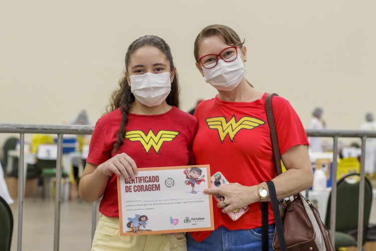 Laura Ketley Santos, 10, e Leidiane Santos, 39, mãe e filha, foram combinando com blusas da Mulher-Maravilha. "Super-heroínas que venceram a Covid", disse Laura.