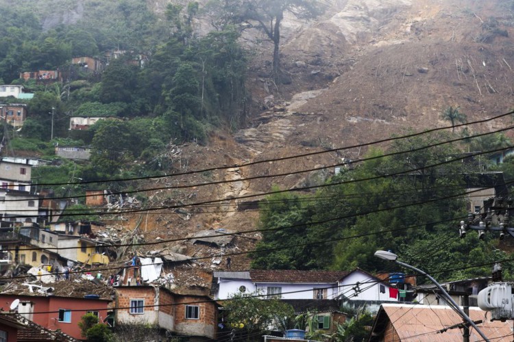 Perfil fake tenta desviar doações destinadas a vítimas das chuvas em Petrópolis. Bombeiros (Foto: moradores e voluntários trabalham no local do deslizamento no Morro da Oficina, após a chuva que castigou Petrópolis)