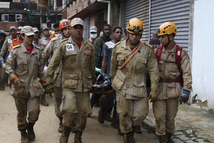 Bombeiros, moradores e voluntários trabalham no local do deslizamento no Morro da Oficina, após a chuva que castigou Petrópolis, na região serrana fluminense